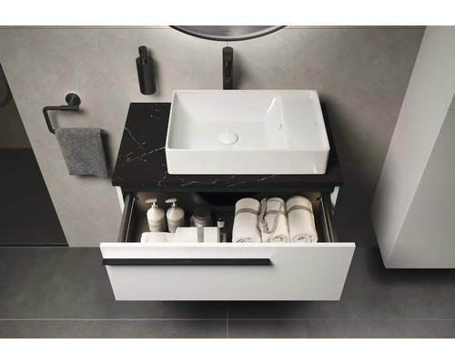 Salle de bain avec lavabo, meuble-lavabo avec tiroir, serviettes et accessoires de bain.