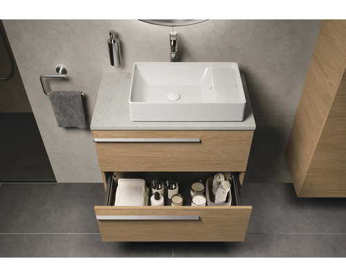 Meuble-lavabo de salle de bains avec tiroir ouvert, serviettes, bougies et produits cosmétiques