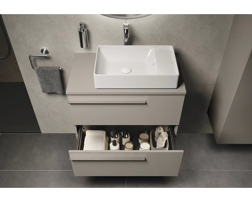Meuble-lavabo de salle de bains avec tiroir ouvert, serviettes, cosmétiques et lavabo