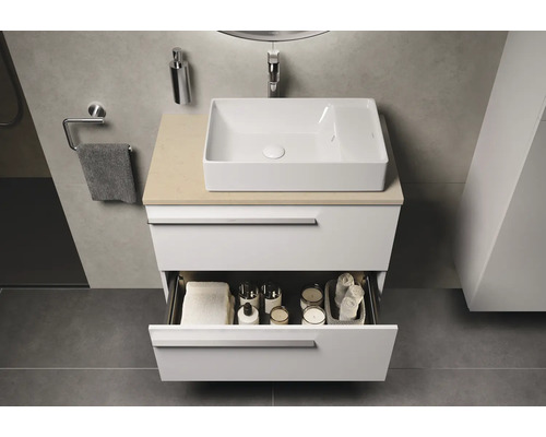 Salle de bains moderne avec lavabo sur meuble bas avec tiroir ouvert et accessoires de salle de bains