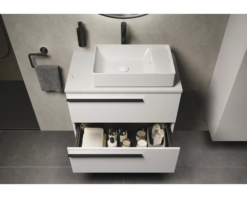 Salle de bains moderne avec meuble-lavabo blanc, vasque à poser, tiroir ouvert et accessoires