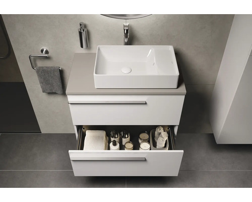 Salle de bain moderne avec lavabo, meuble bas avec tiroir ouvert et accessoires de bain
