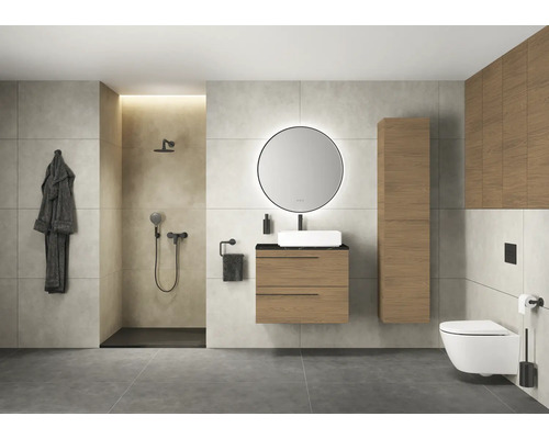 Salle de bains moderne avec douche, lavabo, miroir, toilettes et armoires en bois.