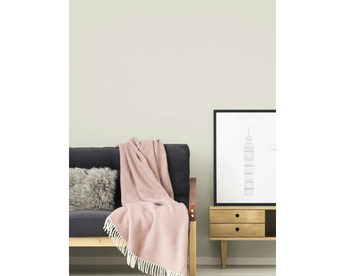 Wohnzimmer mit Sofa, Kissen, Decke, Kommode und gerahmtem Bild