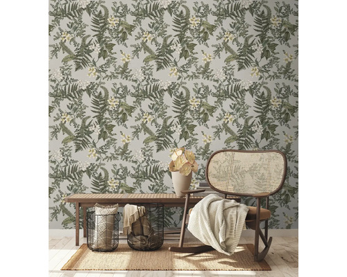 Pièce décorative avec papier peint botanique, banc et rocking-chair en rotin.