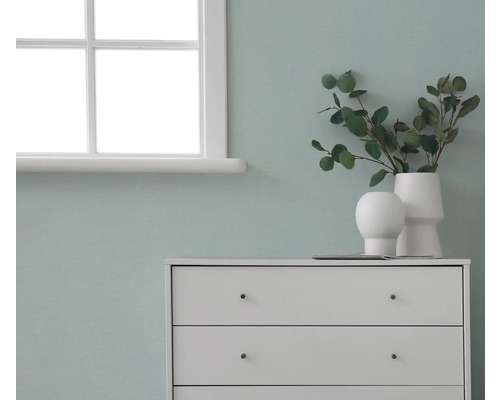 Kommode mit Dekorationsgegenständen vor einer Wand neben einem Fenster