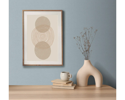 Dekoratives Stillleben mit gerahmtem Kunstdruck, Büchern, Tasse und Vase auf einem Tisch