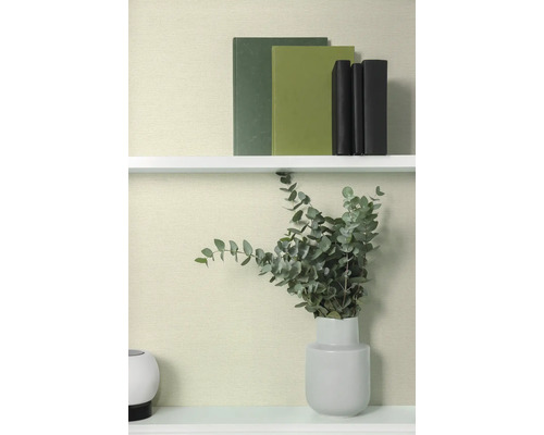 Livres décoratifs et eucalyptus dans un vase sur une étagère.