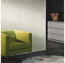 Wohnraum mit Betonoptik Tapete, grünem Sessel und Kommode