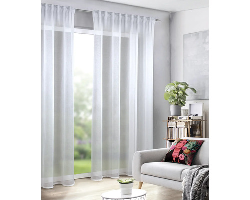 Wohnzimmer mit weißen, transparenten Gardinen vor einem Fenster