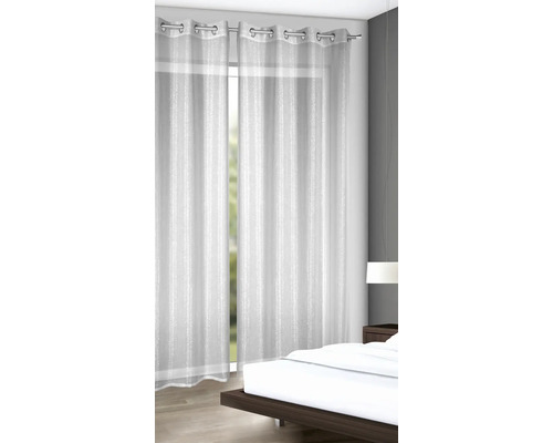Rideaux à œillets en tissu transparent dans la chambre.