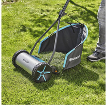 Handrasenmäher auf Rasenfläche mit Grasfangkorb