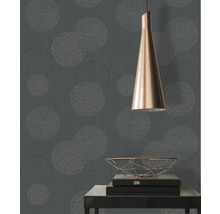 Nahaufnahme einer Wand mit floral gemusterter Tapete, einer Lampe und einem Tisch