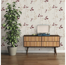 Intérieur avec papier peint à motifs, plante et commode avec tourne-disque