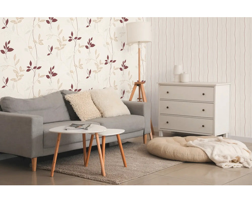 Salon lumineux avec canapé, table basse, commode et papier peint à motifs pour une ambiance conviviale