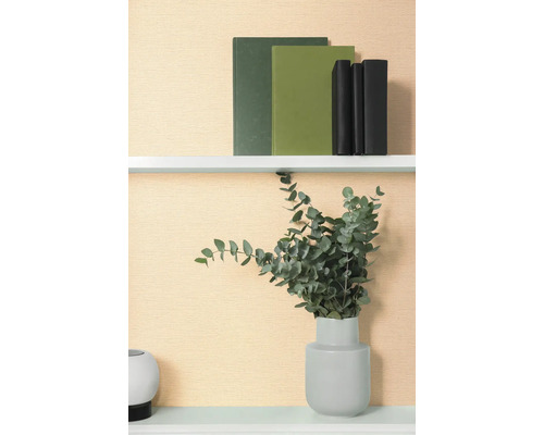 Étagère décorative avec des livres et de l'eucalyptus dans un vase.