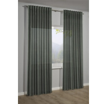 Deux rideaux devant une fenêtre avec vue sur la nature.