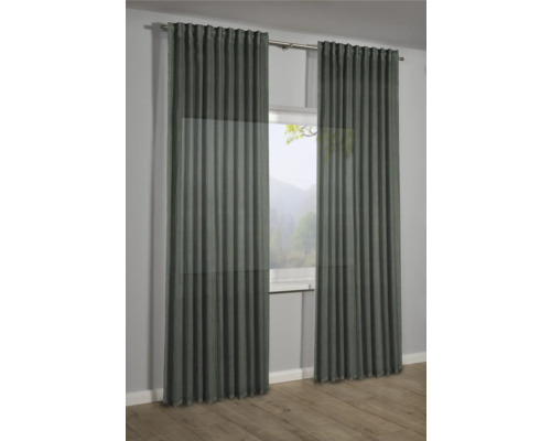 Deux rideaux devant une fenêtre avec vue sur la nature.