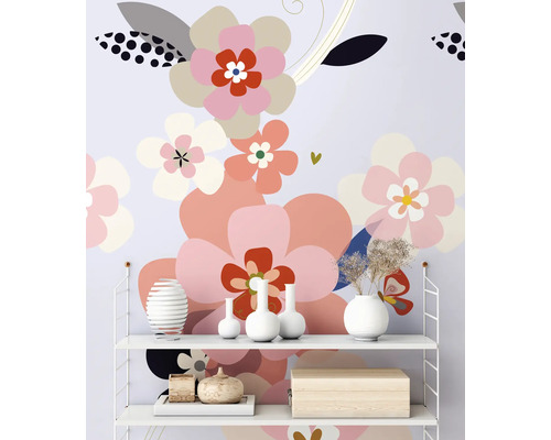 Regal mit dekorativen Objekten vor einer Wandtapete mit Blumenmuster