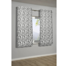 Zwei gemusterte Gardinenschals hängen vor einem Fenster