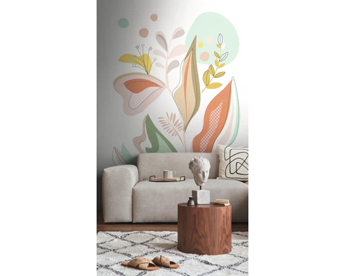 Salon avec canapé, table d'appoint et un mur avec un motif de plantes