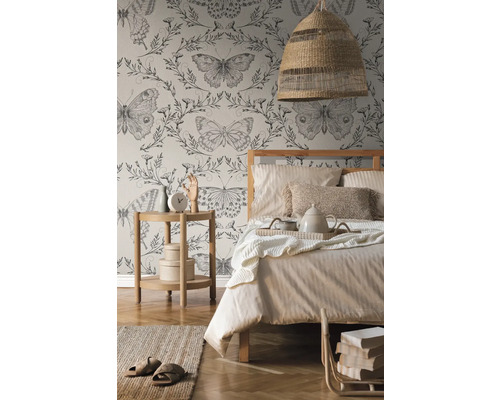 Schlafzimmer mit Bett, Nachttisch, Lampe und Tapete mit Schmetterlingsmuster