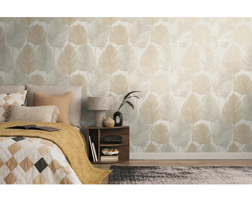 Chambre avec lit et mur avec papier peint à feuilles.