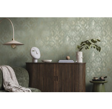 Dekoratives Wohnzimmer mit Kommode, Lampe und Accessoires vor einer gemusterten Tapete