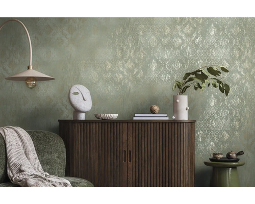 Dekoratives Wohnzimmer mit Kommode, Lampe und Accessoires vor einer gemusterten Tapete