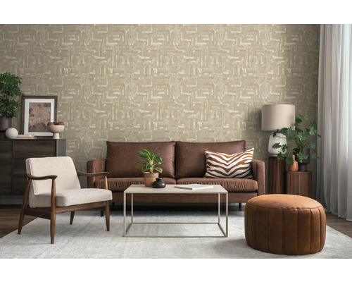 Salon avec canapé, fauteuil, table basse, pouf et papier peint à motifs pour une ambiance cosy.