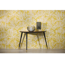 Scène avec console, bougeoir et lampe de table devant un papier peint à motifs