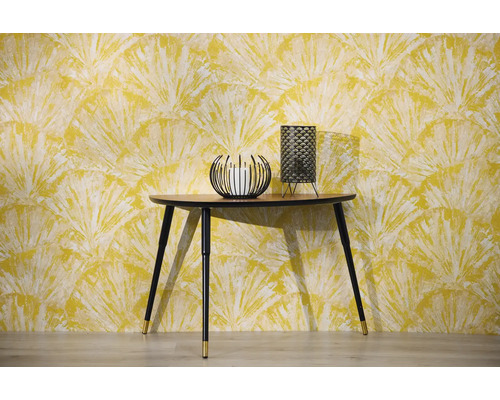 Scène avec console, bougeoir et lampe de table devant un papier peint à motifs