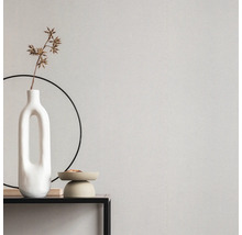 Gros plan d'un mur avec du papier peint, un vase et des accessoires décoratifs sur une table.