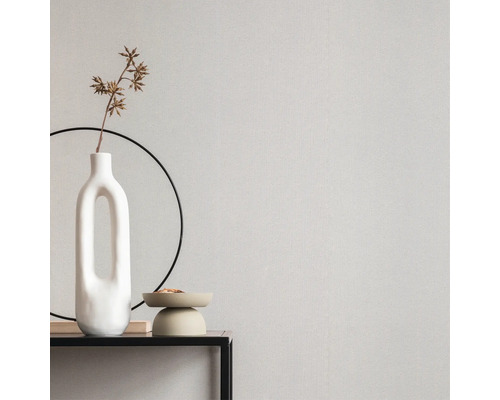 Gros plan d'un mur avec du papier peint, un vase et des accessoires décoratifs sur une table.