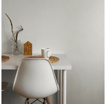 Table blanche avec décorations, dont un verre, une maison en bois et une tasse