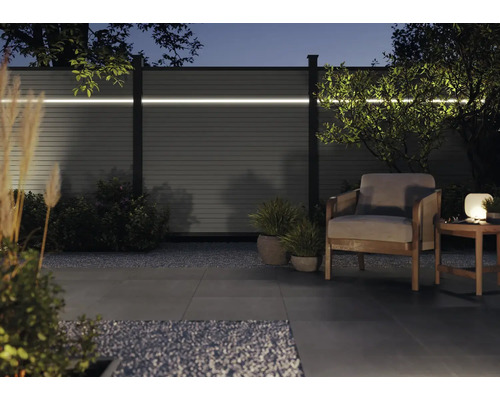 Scène de jardin moderne avec clôture, éclairage et coin salon pour des soirées de détente