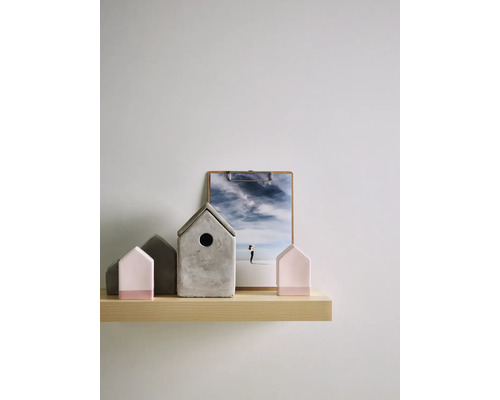 Scène décorative avec des maisons en béton et un presse-papier sur une étagère