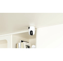 Une caméra de sécurité blanche est montée sous une surface et offre une protection.