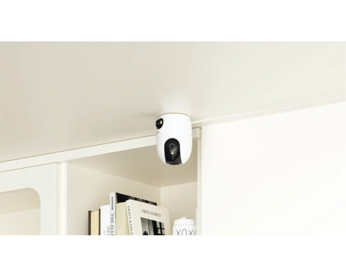 Une caméra de sécurité blanche est montée sous une surface et offre une protection.