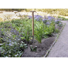 Bêche avec manche en bois dans un parterre de jardin