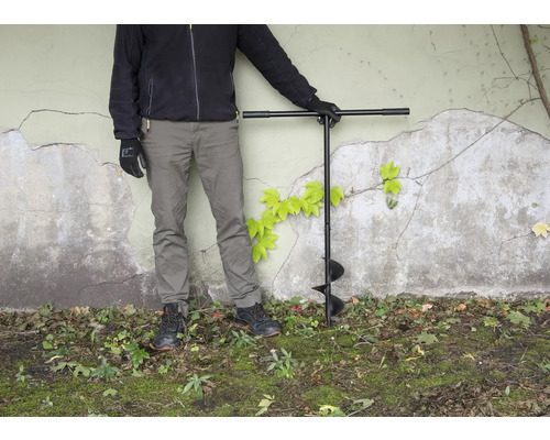 Personne avec tarière dans le jardin