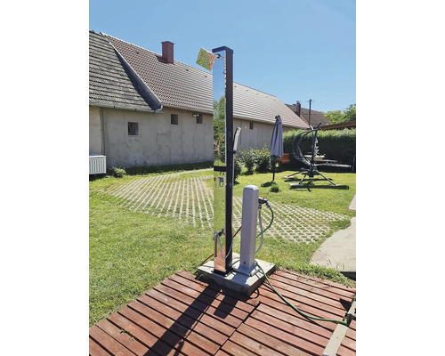 Scène de jardin avec douche et colonne d'eau sur une plateforme en bois