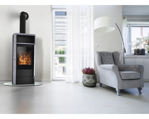 Wohnraum mit Kaminofen, Sessel und Zimmerpflanze