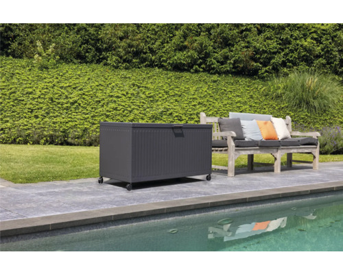 Scène avec un coffre de rangement à roulettes à côté d'un banc de jardin sur une terrasse près d'une piscine