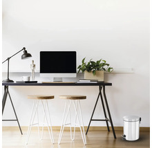 Scène de bureau avec bureau, ordinateur, lampe, chaises et poubelle à pédale