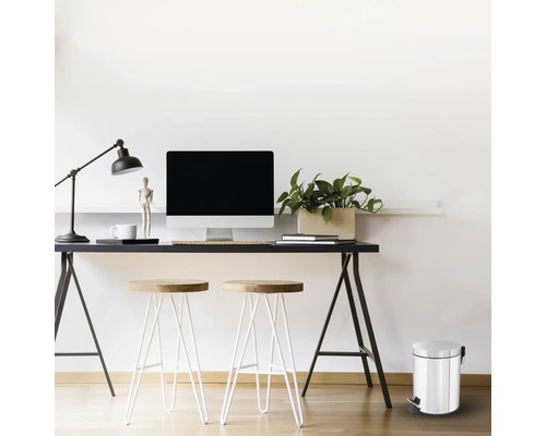 Scène de bureau avec bureau, ordinateur, lampe, chaises et poubelle à pédale