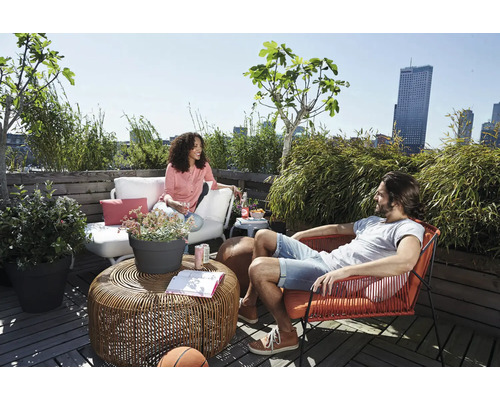 Scène de terrasse avec mobilier de salon, table et personnes détendues
