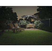 Aménagement paysager de jardin avec parasol éclairé, banc de jardin et deux chaises longues sur une pelouse