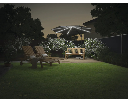 Aménagement paysager de jardin avec parasol éclairé, banc de jardin et deux chaises longues sur une pelouse