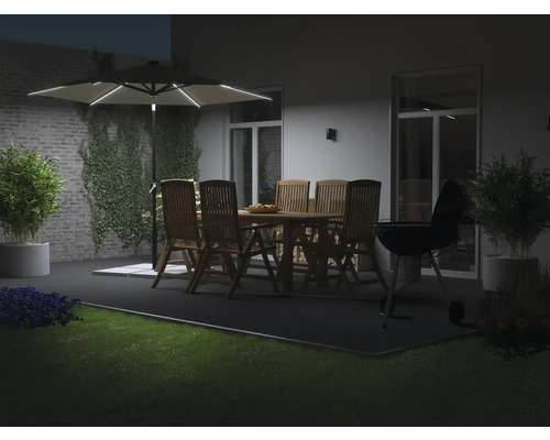 Abendliche Gartenszene mit Gartentisch, Stühlen, Grill und beleuchtetem Sonnenschirm